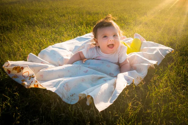 Çocuk çimlere bir altı aylık kız yatıyor.
