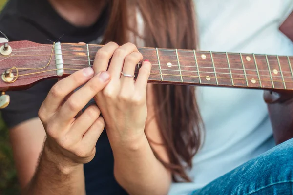 一个男人和一个女孩的手在吉他编曲 学会在公园的草坪上弹吉他 — 图库照片