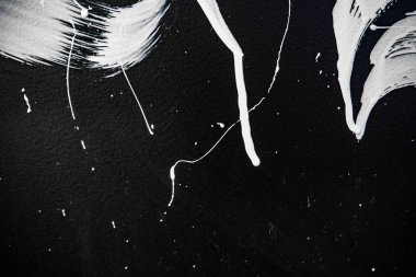 Doku bir siyah duvar, duvar yazısı, sokak sanatı üzerinde beyaz boya. Fırça ve fırça izleri