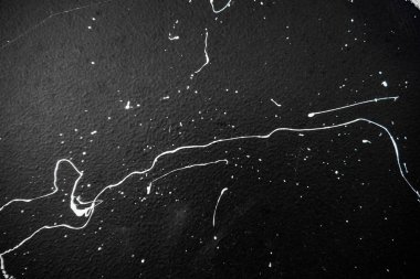 Doku bir siyah duvar, duvar yazısı, sokak sanatı üzerinde beyaz boya. Fırça ve fırça izleri