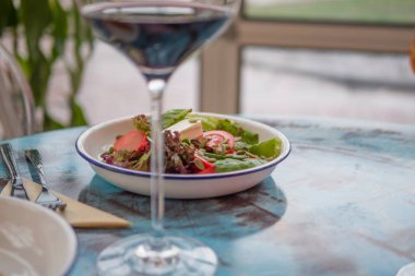 Lezzetli bir salata yeşillikleri kafede masada ile. Beyaz bir tabak salata