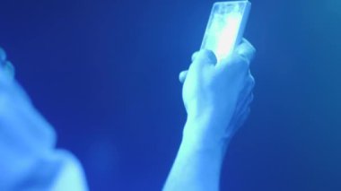 Bir adam bir partide bir telefonla Sms yazıyor. El ve telefon çerçevesinde