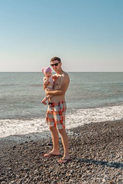 Babam ve kızı sahilde. deniz kıyısı, güneşli yaz günü