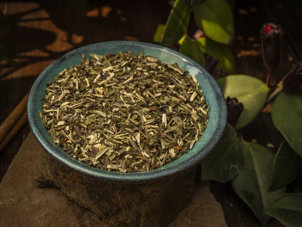 Shredded herbal teh. Dalam piring kecil pirus di atas batu. Tongkat kayu manis — Stok Foto