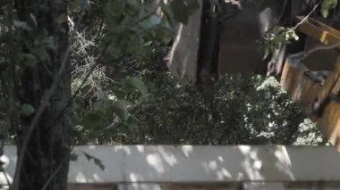 Bir traktör yeni asfalt döşemeden önce, bir konut binanın avlusında inşaat enkaz kaldırır. Güneşli yaz günü.