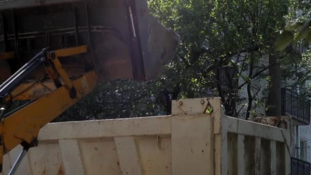 拖拉机在铺设新的沥青之前 先清除住宅建筑庭院中的建筑碎片 阳光明媚的夏日 — 图库视频影像