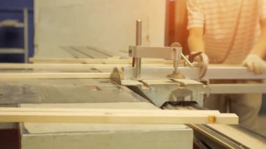 Marangozluk atölyesinde çalışan bir makineüzerinde testere panoları