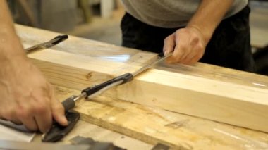 Marangozluk atölyesinde bir zanaatkar metal kelepçeler ile ahşap plakalar kelepçeler