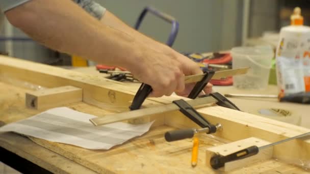 Een Ambachtsman Een Timmerwerk Workshop Klemmen Houten Planken Met Metalen — Stockvideo