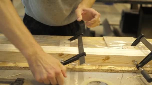 Řemeslník Truhlářské Dílně Upíná Dřevěné Desky Kovovými Svorkami — Stock video