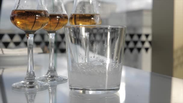 薄い足の上にグラスでウイスキー カクテルパーティーウイスキーの試飲 — ストック動画