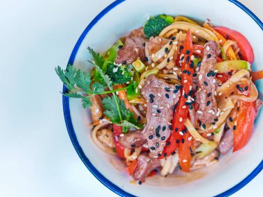 Beyaz bir tabakta etli Udon eriştesi.