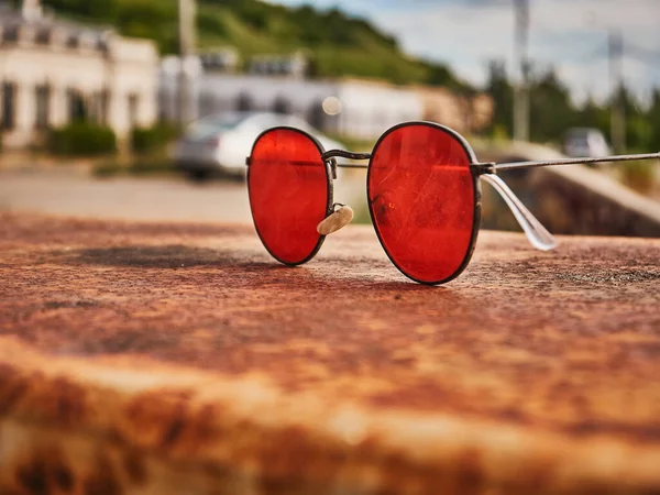 Stare Czerwone Okulary Przeciwsłoneczne Betonowej Powierzchni Podrapane Szkło Dzień — Zdjęcie stockowe
