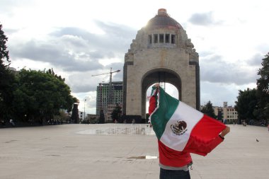 Mexico City, Mexico - 23 Ağustos 2023: İnsanlar ulusal bayramları kutlamak için Devrim Anıtı önünde gururla bayrak kaldırdı