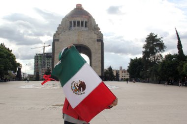 Mexico City, Mexico - 23 Ağustos 2023: İnsanlar ulusal bayramları kutlamak için Devrim Anıtı önünde gururla bayrak kaldırdı