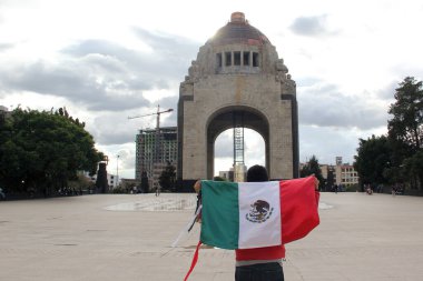 Mexico City, Mexico - 23 Ağustos 2023: İnsanlar ulusal bayramları kutlamak için Devrim Anıtı önünde gururla bayrak kaldırdı