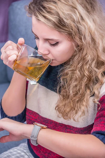 girl drinking tea and looking at the clock, quick Breakfast and lack of time for food