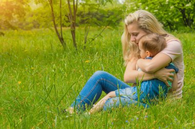 Anne ve çocuk da güneşli havalarda mutlu aile yeşil çimenlerin üzerinde dinlenme Park, doğada