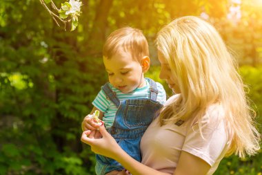 Anne ve çocuk da güneşli havalarda mutlu aile yeşil çimenlerin üzerinde dinlenme Park, doğada
