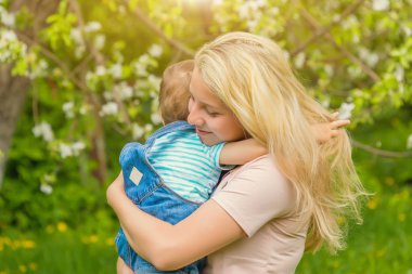 Anne ve çocuk da güneşli havalarda mutlu aile yeşil çimenlerin üzerinde dinlenme Park, doğada