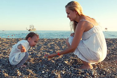 Anne ile çocuk on the beach Side, Türkiye, deniz eski geminin arka planı