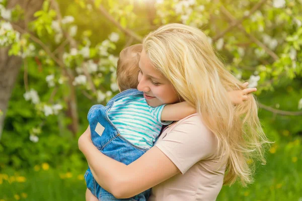 Anne ve çocuk da güneşli havalarda mutlu aile yeşil çimenlerin üzerinde dinlenme Park, doğada