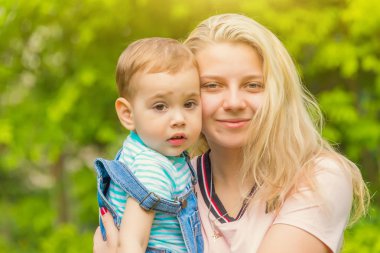 Anne ve çocuk da güneşli havalarda mutlu aile yeşil çimenlerin üzerinde dinlenme Park, doğada
