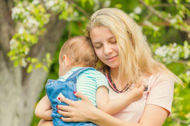 Anne ve çocuk da güneşli havalarda mutlu aile yeşil çimenlerin üzerinde dinlenme Park, doğada