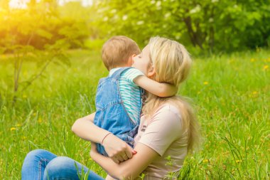 Anne ve çocuk da güneşli havalarda mutlu aile yeşil çimenlerin üzerinde dinlenme Park, doğada