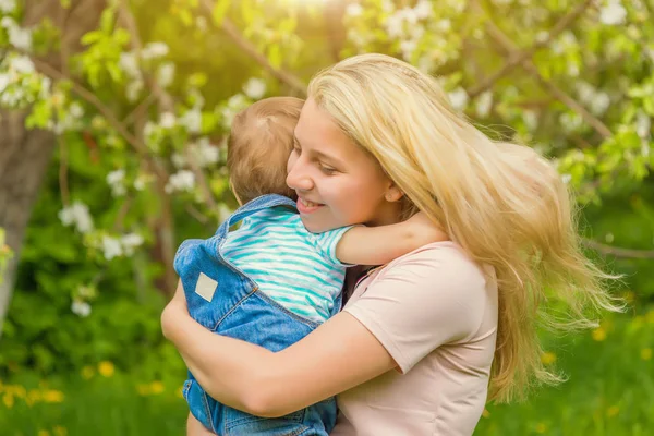 Anne ve çocuk da güneşli havalarda mutlu aile yeşil çimenlerin üzerinde dinlenme Park, doğada