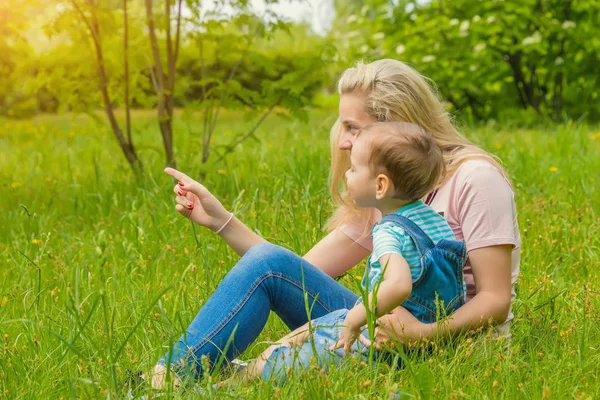 Anne ve çocuk da güneşli havalarda mutlu aile yeşil çimenlerin üzerinde dinlenme Park, doğada