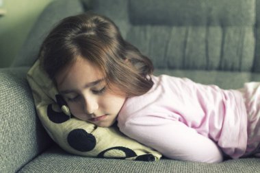 çocuk gece elbiseli yorgun, hasta, kanepeye uzandı, depresyona girmiş