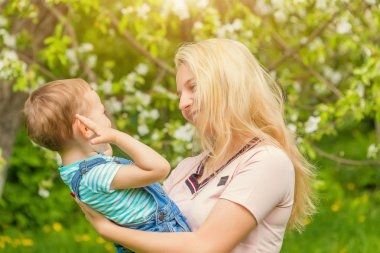Anne ve çocuk da güneşli havalarda mutlu aile yeşil çimenlerin üzerinde dinlenme Park, doğada