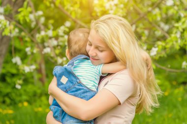 Anne ve çocuk da güneşli havalarda mutlu aile yeşil çimenlerin üzerinde dinlenme Park, doğada