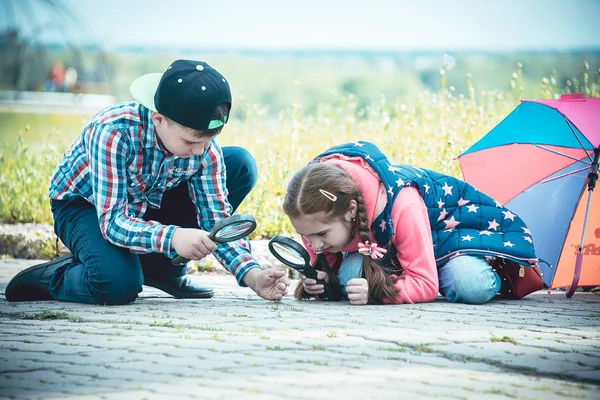 子供たちは公園 少年と円満を虫眼鏡で夏に歩く女の子に歩く — ストック写真