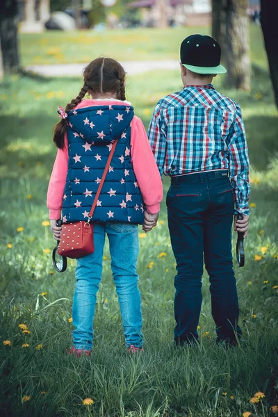 Çocuk Parkı, bir çocuk ve bir kız dostça bir büyüteç ile yaz aylarında yürüyüş yürüyüş