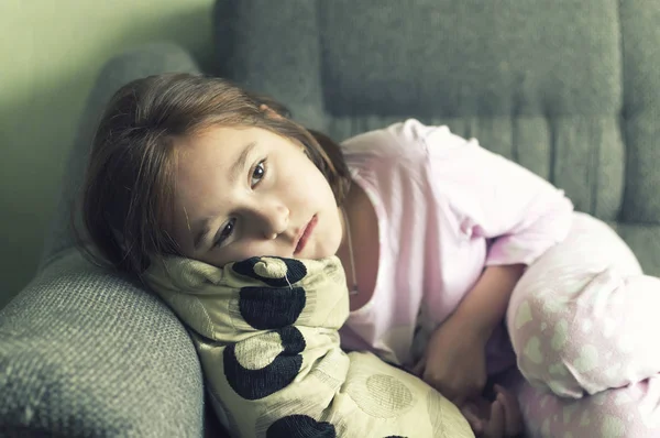 çocuk gece elbiseli yorgun, hasta, kanepeye uzandı, depresyona girmiş
