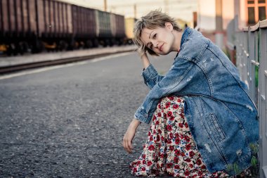 Kız kafasını peron kafayla elinde oturur