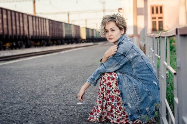 Kız kafasını peron kafayla elinde oturur