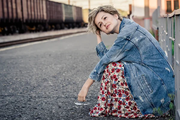 Kız kafasını peron kafayla elinde oturur