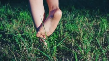 doğada bir yaz parkta yeşil, dikenli çimenlerin üzerinde çıplak ayak