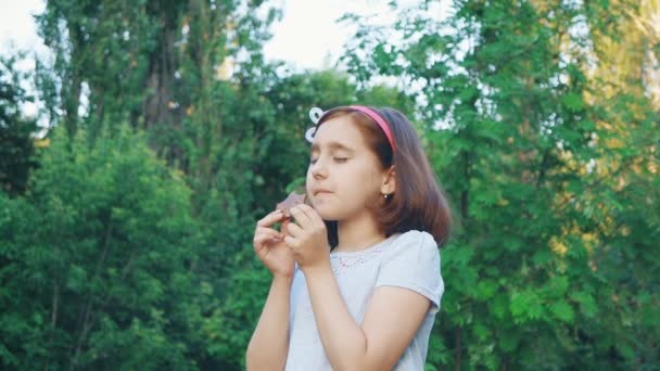 Küçük Kız Yeme Çikolata Kapalı Gözlerle Zevk Ile Başını Sallayarak — Stok video