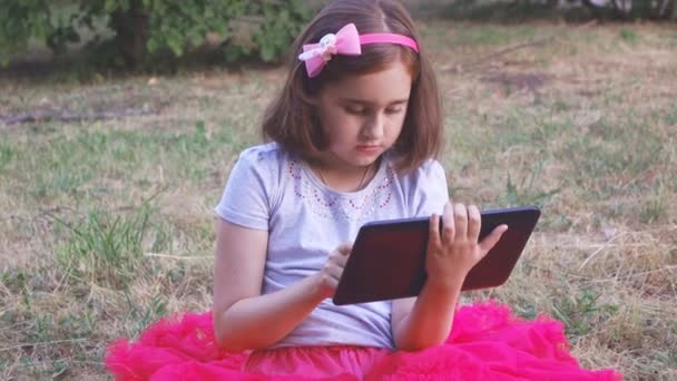 Little Artist Girl Red Skirt Plays Tablet Sitting Grass Forest — Stock Video