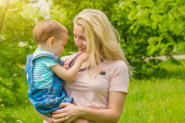 Anne ve çocuk da güneşli havalarda mutlu aile yeşil çimenlerin üzerinde dinlenme Park, doğada