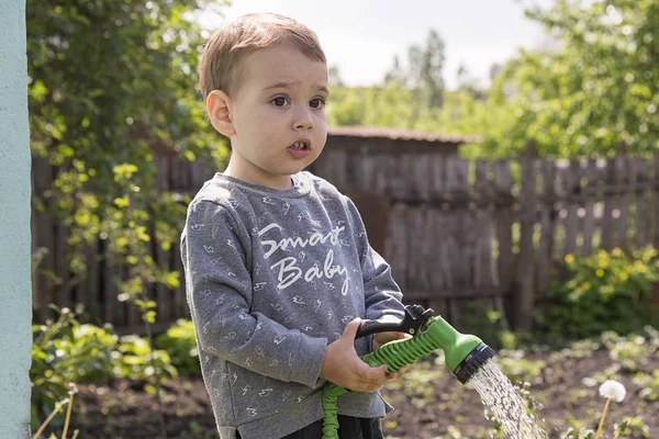 Een Kind Tuin Drenken Bloemen Een Jongetje Met Een Waterslang — Stockfoto