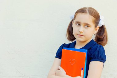 kız çocuk duvar arka plan üzerinde ders kitapları ile okul için hazırlanıyor