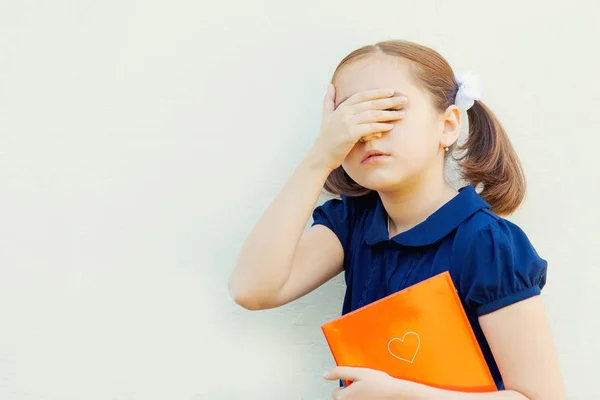 壁の背景に教科書と女児は学校の準備します — ストック写真