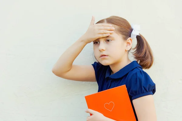 壁の背景に教科書と女児は学校の準備します — ストック写真