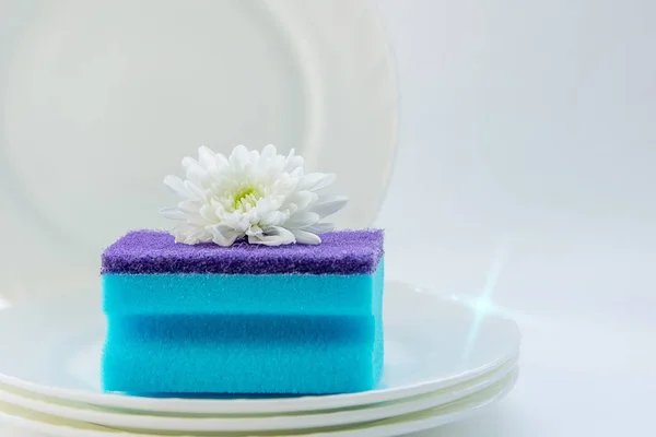 dish washing sponge on clean dishes close up on white background