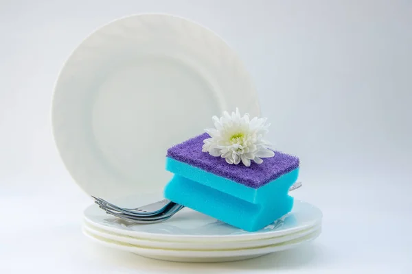 dish washing sponge on clean dishes close up on white background